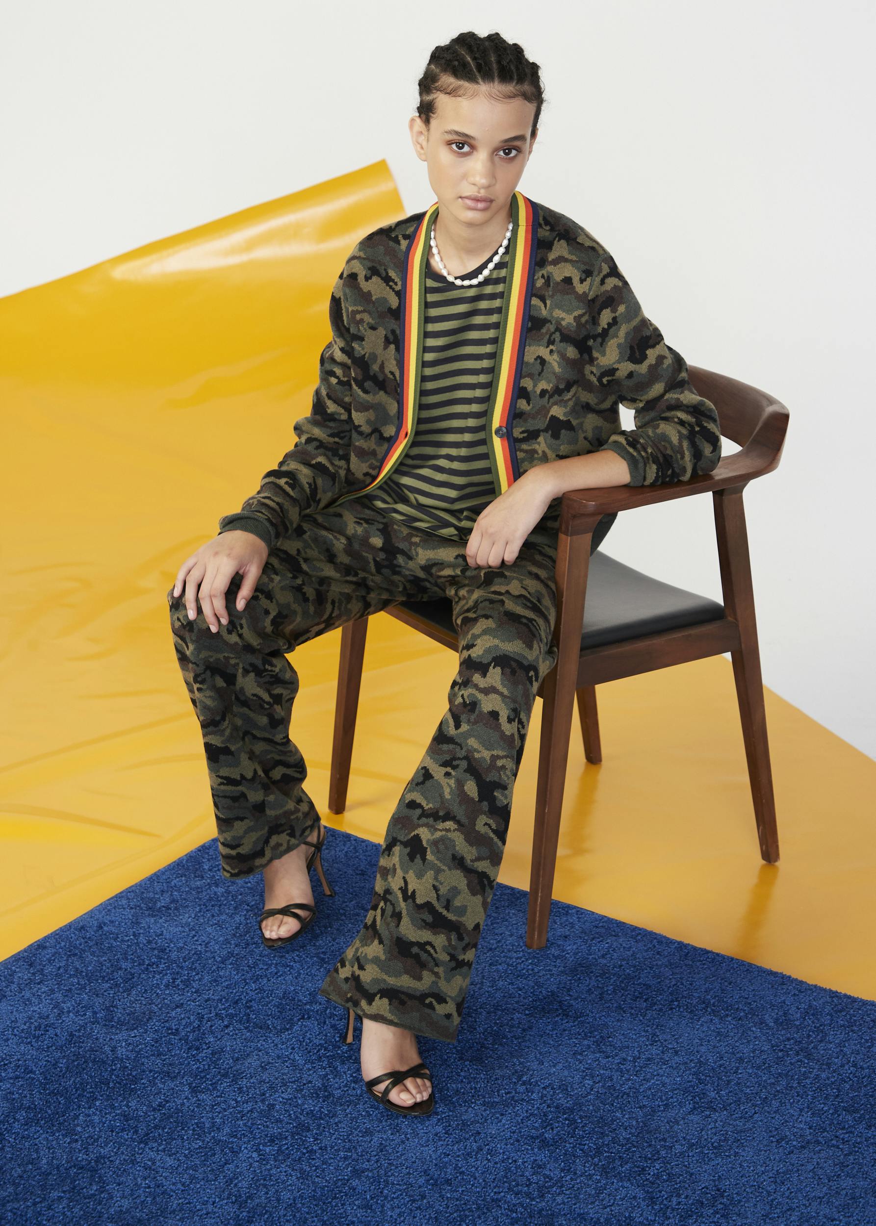 Cool woman in a KULE camouflage knit set for fall sitting on a chair